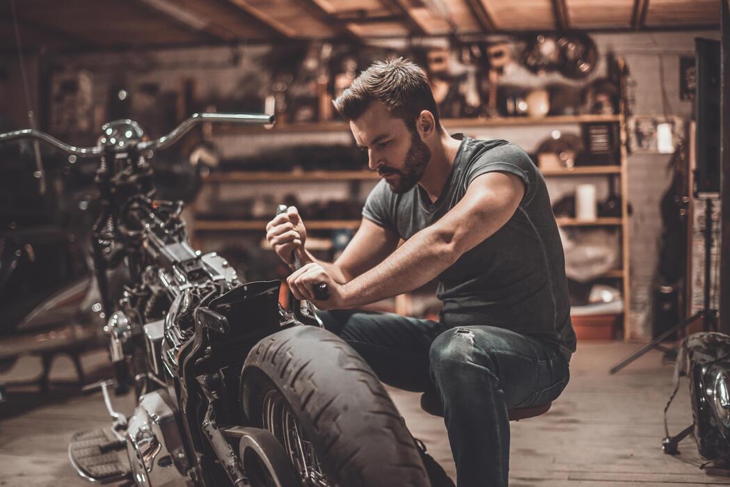 This bike will be perfect. Confident young man repairing motorcycle in repair  shop 13576040 Stock Photo at Vecteezy