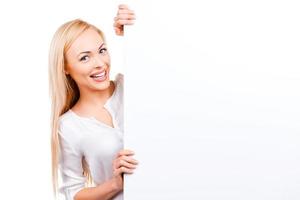 Your advertisement in her hands. Beautiful mature women holding hands on copy space and looking at camera while standing against white background photo