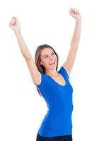 I did it Happy young smiling woman keeping arms raised while standing isolated on white photo