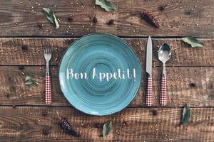 Dinner time. High angle shot of empty plate, fork, spoon, knife lying on rustic table photo