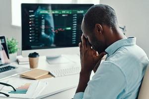 Tired young African man in shirt taking a pause while working in the office photo