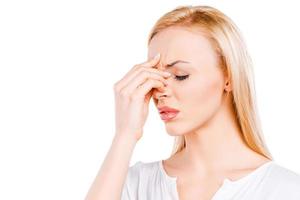 My head is breaking off. Depressed mature women touching her head and keeping eyes closed while standing against white background photo