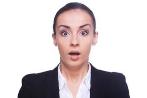 Shocked businesswoman. Surprised young woman in formalwear looking at camera and keeping mouth open while standing isolated on white photo