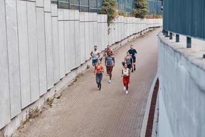 vista superior completa de los jóvenes en ropa deportiva trotando mientras hacen ejercicio al aire libre foto