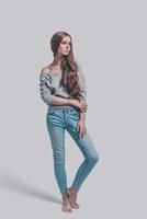 Casual beauty. Full length of attractive young woman in casual wear posing against grey background photo