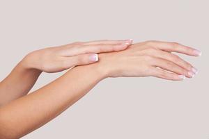 Hands care. Close-up of beautiful female hands isolated on grey photo