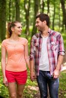 Good day to walk in park. Beautiful young loving couple walking in park and holding hands photo