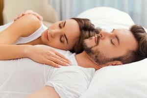 Feeling calm and comfortable. Beautiful loving couple sleeping together in bed photo
