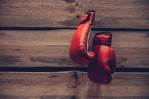 Boxing gloves. Close-up of boxing gloves hanging on vintage wooden wall photo