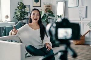 Sharing some fresh ideas. Beautiful young woman gesturing and smiling while making new video for her blog photo