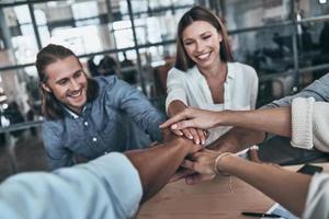 Best team. Top view of business colleagues holding hands on top of one another in a symbol of unity while working in the board room photo
