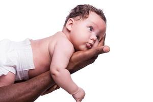 Cute baby. Side view of black hands holding cute little baby while isolated on white background photo