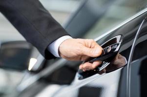 abriendo su coche nuevo. primer plano de la mano masculina que sostiene la manija del coche foto