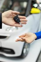 She has made a right choice. Close-up shoot of the car salesman hand giving the key to female owner photo