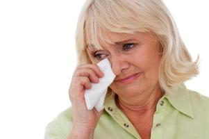 Senior woman crying. Depressed senior woman crying while standing isolated on white background photo