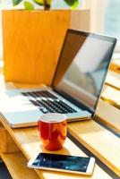 Everything you need for good work. Close-up of office desk with laptop and mobile phone laying on it photo