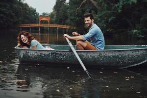 Playful couple. Beautiful young couple smiling while enjoying romantic date on the lake photo