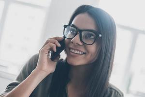 Good news Confident young woman in smart casual wear talking on the mobile phone and smiling photo