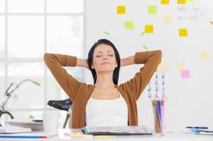 Business woman relaxing. Business woman relaxing with hands behind head and smiling photo