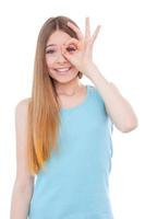 Making a face. Happy teenage girl having fun while standing isolated on white photo