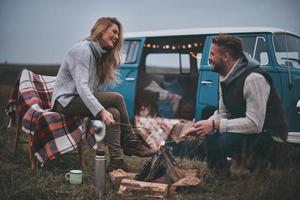 deja todas tus preocupaciones atrás. hermosa pareja joven asando malvaviscos sobre una fogata mientras disfruta de su viaje por carretera foto