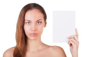 Feel the difference. Portrait of beautiful young woman with half face make-up holding a copy space and looking at camera while standing isolated on white background photo