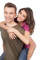 Beautiful loving couple. Cheerful young loving couple hugging and smiling at camera while standing isolated on white photo