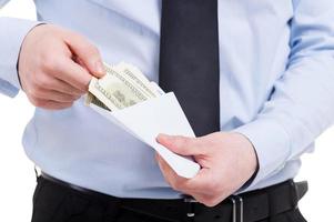 Bribe. Cropped image of man in shirt and tie taking money from the envelope while standing isolated on white photo