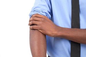 Ready to work. Close-up of black man in shirt and tie adjusting his sleeves while isolated on grey photo