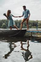 Always happy together. Happy young couple holding hands and smiling while enjoying their date outdoors photo