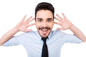 hombre de negocios emocionado. joven feliz con camisa y corbata mirando a la cámara y tocándose la cabeza con las manos mientras se enfrenta a fondo blanco foto