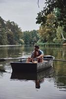 Carrying about her. Beautiful young couple embracing while enjoying romantic date on the lake photo