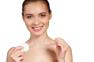 Dental cleaning. Beautiful young woman holding dental floss and smiling at camera while isolated on white background photo