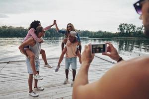 hermosas parejas jóvenes que pasan tiempo sin preocupaciones mientras están de pie en el muelle foto