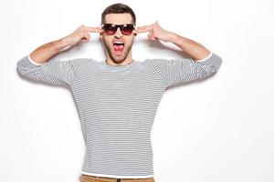Am I crazy Excited young man gesturing and keeping mouth open while standing against white background photo