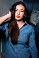 Following her personal style. Close Up image of beautiful young woman in jeans shirt wear holding hand on head