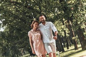 Real love. Beautiful young couple bonding and smiling while walking in the park together photo