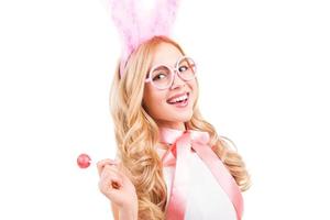 Easter bunny with lollipop. Beautiful young blond hair woman with rabbit ears holding lollipop and smiling while standing isolated on white background photo