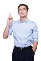 Brilliant idea Thoughtful young man in blue shirt gesturing and looking away while standing isolated on white photo