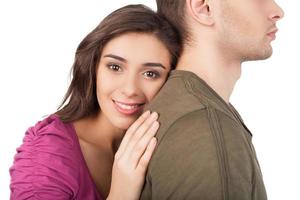 True love. Cheerful young woman hugging her boyfriend and looking at camera while standing isolated on white photo