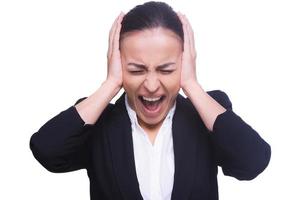 Emotional stress. Frustrated young woman in formalwear covering ears with hands and keeping eyes closed while standing isolated on white photo