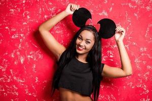 Funky beauty. Playful young African woman in mouse ears posing against white background photo