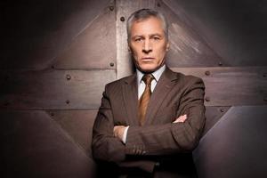 Power in his veins. Confident senior man in formalwear holding arms crossed and looking at camera photo