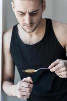 Heroin boiling. Young man boiling heroin in spoon photo