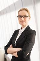 Confident business woman. Beautiful mature woman in formalwear keeping arms crossed and looking at camera photo