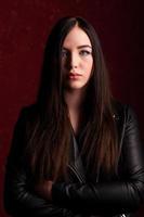 Confident beauty. Beautiful young woman in black jacket looking at camera and holding her arms crossed photo