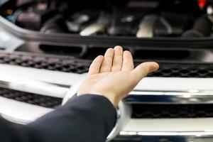 Aquí está tu coche nuevo. toma de primer plano de la mano que presenta un coche foto