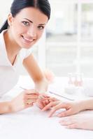 She is manicure expert. Close-up of manicure master at work photo
