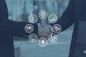 Business concept. Close-up of two young businessmen shaking hands while standing outdoors photo