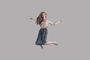 Moving free. Studio shot of attractive young woman hovering in air photo